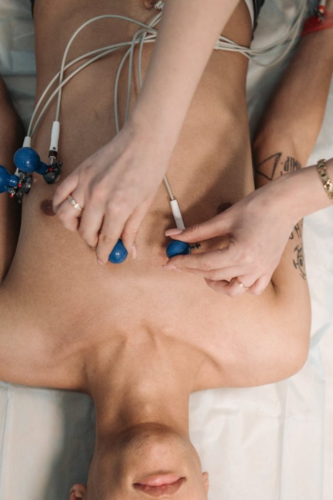 Close-up of a healthcare professional placing ECG electrodes on a patients chest for heart monitoring.